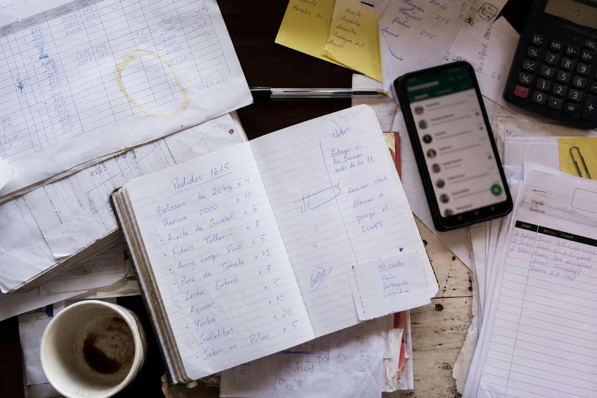Pedidos, notas y WhatsApp en un escritorio. El trabajo todavía a mano